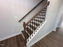 Elegant staircase featuring hardwood steps, white risers, and stylish black iron balusters at 308 White Oak Garden Way # 215, Garner, NC 27529