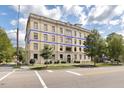 Classic multi-story apartment building featuring yellow brick, mature trees, and professional landscaping at 312 N Buchanan Blvd # 302, Durham, NC 27701