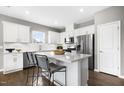 A modern kitchen boasts stainless steel appliances, white cabinetry, an island, and bar stool seating at 345 Broomside Ave, Raleigh, NC 27603