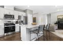 Modern kitchen features stainless steel appliances, white cabinets, and an island with bar stool seating at 345 Broomside Ave, Raleigh, NC 27603