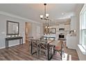 Open-concept dining area with a modern table, leading to a bright kitchen with stainless steel appliances at 37 E American Marigold Dr # 35, Benson, NC 27504