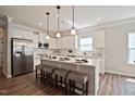Bright, open kitchen featuring white cabinets, stainless steel appliances, a large center island and breakfast bar seating at 37 E American Marigold Dr # 35, Benson, NC 27504