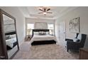 Serene main bedroom with tray ceilings, a king bed, neutral tones, and natural light from two windows at 37 E American Marigold Dr # 35, Benson, NC 27504