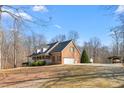 Spacious brick home with an attached garage, covered front porch, and a sprawling lawn at 4639 Reid Rd, Elon, NC 27244