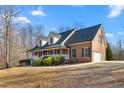 Beautiful brick home featuring an attached two car garage and covered front porch on a sunny day at 4639 Reid Rd, Elon, NC 27244