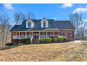 Inviting brick home with a full front porch and dormer windows providing extra light at 4639 Reid Rd, Elon, NC 27244