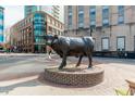 Bronze bull sculpture displayed in a vibrant downtown neighborhood with modern buildings at 521 N Mangum St # 33, Durham, NC 27701