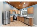 Kitchen featuring stainless steel appliances, wood cabinets, and a bright window above the sink at 701 Black Pearl Cv, Rocky Mount, NC 27804