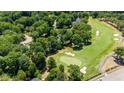 Expansive aerial view showcasing a lush golf course with mature trees and surrounding homes at 7621 Wingfoot Dr, Raleigh, NC 27615