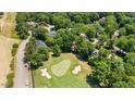 Scenic aerial view of a well-maintained golf course surrounded by trees and residential homes at 7621 Wingfoot Dr, Raleigh, NC 27615