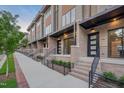 Sidewalk view of modern townhomes showcasing brick facade, black railings and inviting entries at 777 Willard St, Durham, NC 27701