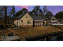 Back of the home with a screened porch next to a lake with dock access at 79 Cove Lndg, Sanford, NC 27332