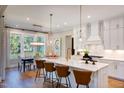 Bright kitchen boasts white cabinets, marble countertops, a large island, and stainless steel appliances at 83 Stickleback Dr, Willow Springs, NC 27592