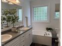 Bright bathroom with double vanity, soaking tub, and stylish tile flooring at 10 Georgetown Woods Dr, Youngsville, NC 27596