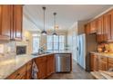 Well-lit kitchen featuring stainless steel appliances, stone countertops, and wood cabinetry at 10 Georgetown Woods Dr, Youngsville, NC 27596
