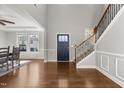 Bright foyer boasts soaring ceilings, hardwood floors, and an elegant staircase with iron balusters at 104 Highland Mist Cir, Apex, NC 27539