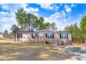 Charming one-story home with a welcoming front porch, complemented by a well-maintained front yard and mature trees at 112 Mckoy Town Rd, Cameron, NC 28326