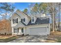 Charming two-story home with a well-manicured lawn and attached two car garage at 112 Wellspring Dr, Holly Springs, NC 27540