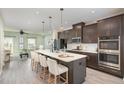 Modern kitchen with dark cabinets, quartz counters, an island with seating, and stainless appliances at 113 Callowhill Ln, Durham, NC 27713