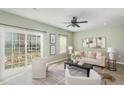 Bright living room featuring neutral decor, a ceiling fan, large windows, and a sliding glass door at 113 Callowhill Ln, Durham, NC 27713