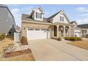 Beautiful two-story brick home featuring a spacious driveway and a welcoming front porch at 117 Blue Hydrangea Ln, Holly Springs, NC 27540