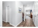 Bright hallway with hardwood floors, neutral walls, and decorative accents at 117 Blue Hydrangea Ln, Holly Springs, NC 27540