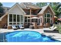 Backyard oasis featuring a sparkling swimming pool, lounge chairs, and a covered patio area at 12085 Morehead, Chapel Hill, NC 27517