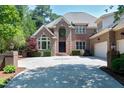 Elegant brick home showcasing a large driveway, arched windows, and mature landscaping at 12085 Morehead, Chapel Hill, NC 27517