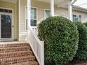 Close-up of a charming home's front porch with brick steps and a painted white railing at 1219 E Middleton Dr, Creedmoor, NC 27522