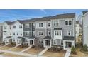 Modern townhomes with gray siding, stone accents, covered entries, and landscaped front yards offer curb appeal at 1430 Rosepine Dr, Cary, NC 27519