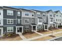 Modern townhomes with gray siding, stone accents, covered entries, and landscaped front yards offer curb appeal at 1430 Rosepine Dr, Cary, NC 27519