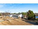Property featuring a well-kept home with a blue roof, lush greenery, and a peaceful pond at 186 Sunrise Dr, Sanford, NC 27332