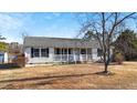 A front view of a cozy single-story home with a covered porch and classic black shutters at 186 Sunrise Dr, Sanford, NC 27332