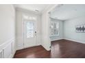 Bright foyer featuring a decorative glass door, fresh white paint, and rich wood floors leading to the main rooms at 1951 Mostyn Ln, Apex, NC 27502