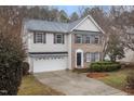 Two-story home featuring brick and siding exterior, trimmed bushes, and a two-car garage at 2114 Frissell Ave, Apex, NC 27502