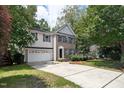 Charming two-story home featuring vinyl and brick siding, an attached garage, and a spacious driveway at 2114 Frissell Ave, Apex, NC 27502