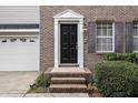 Close-up of the front door with brick steps, classic white trim, and well-maintained landscaping at 2114 Frissell Ave, Apex, NC 27502