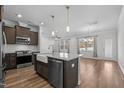 Open kitchen boasts a center island with granite countertops, stainless steel appliances, and wood floors at 236 Shingle Oak Rd, Wake Forest, NC 27587