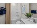 Clean bathroom with a shower-tub combo, a light countertop, and a decorative leafy plant at 24 Saddle Mare St, Clayton, NC 27520