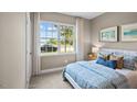 Cozy bedroom featuring a patterned bedspread, decorative pillows, and a view of the outdoors at 24 Saddle Mare St, Clayton, NC 27520