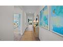 Bright hallway with decorative art and a jute rug that leads into a bedroom and living area at 24 Saddle Mare St, Clayton, NC 27520