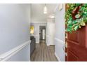 View from doorway, highlighting the foyer, wood floors, stainless steel refrigerator and grey sofa at 2820 Bedfordshire Ct, Raleigh, NC 27604