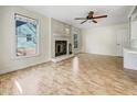 Spacious living room with a brick fireplace, hardwood floors, a ceiling fan, and large windows at 308 Trimble Ave, Cary, NC 27511