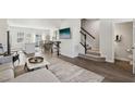 Open-concept living room with hardwood floors, staircase, and lots of light for a modern and inviting space at 4918 Neuse Commons Ln, Raleigh, NC 27616