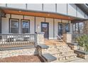 Inviting covered porch with stone pillars, seating, and a wreath on the front door at 723 Holloway St, Durham, NC 27701