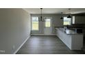 Bright dining area featuring modern chandelier, large windows and a door to the backyard at 73 Grace Pond Ave, Benson, NC 27504