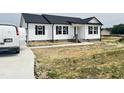 New home with white siding, black shutters, concrete walkway, and freshly poured driveway at 73 Grace Pond Ave, Benson, NC 27504