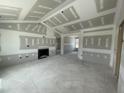 A bare living room with unpainted drywall, an elegant fireplace, and an archway leading to other rooms at 73 Grace Pond Ave, Benson, NC 27504