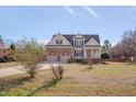Traditional home featuring a two-car garage, complemented by a spacious front yard and mature trees at 100 Watkins Farm Rd, Rolesville, NC 27571