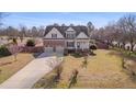 Inviting two-story residence showcasing a manicured lawn, mature trees, and an extended driveway at 100 Watkins Farm Rd, Rolesville, NC 27571
